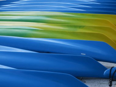 a collection of blue , yellow and green  canoes  laying upward down  clipart