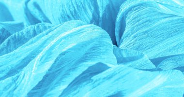 İpek kumaş. Mavi buruşuk kumaş dokusu. Mavi buruşuk, dalgalı yüzey dokusu. Yakın çekim, yumuşak odaklanma. arkaplan, kalıp