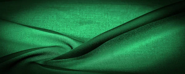 stock image Sheer dark green chiffon silk, Emerald abstract background. Green fabric closeup. - it is a soft transparent fabric with a slight roughness (matte, crepe) due to the use of twisted yarn. texture