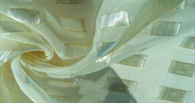 Altın bir çizgi, fildişi pastel, desenli arka plan, desenli kart ile sınırlandırılmış metal kare yerleştirilmiş ipek kumaş.