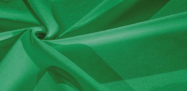 Yeşil ipek. Pürüzsüz, zarif yeşil ipek kumaş, fotokopi alanı ile soyut bir arkaplan olarak kullanılabilir. Renkli doku