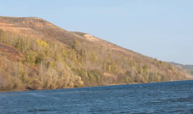 Sonbahar manzarası, Kama 'nın sonbahar manzarası. Parlak gökyüzü, görkemli kayalık dağlar ve güneş ışığıyla parlayan parlak ağaçlarla muhteşem bir sonbahar sahnesi.
