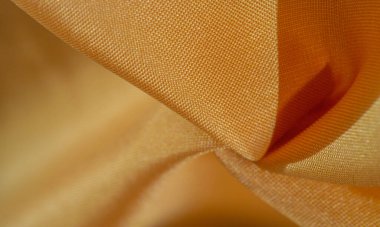Sarı renkli ipek kumaş. Renkli ipek kumaşın dokusu arka plan olarak kullanılabilir
