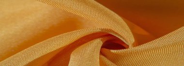 Sarı renkli ipek kumaş. Renkli ipek kumaşın dokusu arka plan olarak kullanılabilir