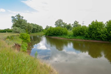 Yaz manzarası, gök gürültülü bulutlar, mavi gökyüzü, sel basmış çayır tarlaları, yaz renklerinin kokusu ve çeşitli kır çiçekleri.