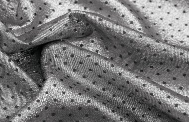 Küçük polka şeklinde metalik bir parıltıya sahip kumaş, siyah, soyut bir polikrom desen, uzay çağı estetiğine sahip siyah bir arkaplan karşısında parıldıyor ve bu kumaşa fütüristik bir gelecek hissi veriyor.