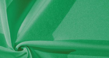 Yeşil ipek. Pürüzsüz, zarif yeşil ipek kumaş, fotokopi alanı ile soyut bir arkaplan olarak kullanılabilir. Renkli doku
