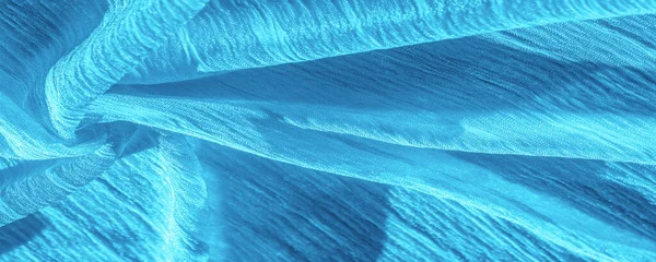 stock image Silk fabric. Texture of blue wrinkled fabric. Blue wrinkled, wavy surface texture. Close-up, soft focus. background, pattern