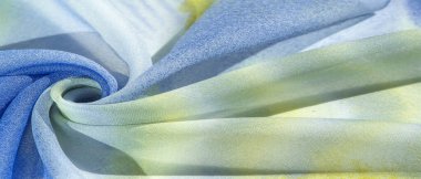 Yumuşak mavi, soyut desenleri ve yatak tonları olan ipek kumaş, sarı ve beyaz tonlarda. Doku, desen, koleksiyon