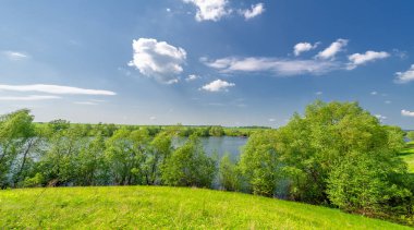 Bahar fotoğrafı, söğüt ağacı, parlak yeşillik, bulutlu mavi gökyüzü, harika bahar havası.