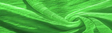 İpek kumaş. Yeşil kırışık kumaş dokusu. Yeşil buruşuk, dalgalı yüzey dokusu. Yakın çekim, yumuşak odaklanma. arkaplan, kalıp