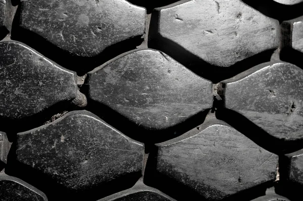 Create a unique texture with a worn tire tread pattern. Use as background for automotive or industrial design. Print on clothing, accessories or packaging for a rugged look