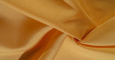 Sarı renkli ipek kumaş. Renkli ipek kumaşın dokusu arka plan olarak kullanılabilir