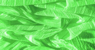 İpek kumaş. Yeşil kırışık kumaş dokusu. Yeşil buruşuk, dalgalı yüzey dokusu. Yakın çekim, yumuşak odaklanma. arkaplan, kalıp