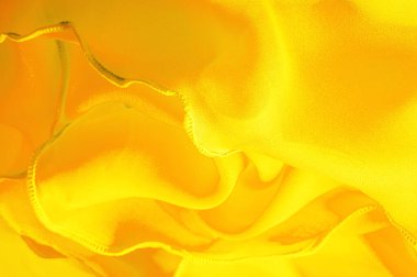 Dalgalı boruları olan sarı ipek organza. Kumaşın kenarındaki sınır. Soyut arkaplan. doku deseni. İpek organzanın narin bir açık dokuması vardır. Dalga arkaplanı. Boşluğu kopyala