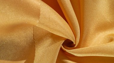 Sarı renkli ipek kumaş. Renkli ipek kumaşın dokusu arka plan olarak kullanılabilir