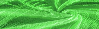 İpek kumaş. Yeşil kırışık kumaş dokusu. Yeşil buruşuk, dalgalı yüzey dokusu. Yakın çekim, yumuşak odaklanma. arkaplan, kalıp