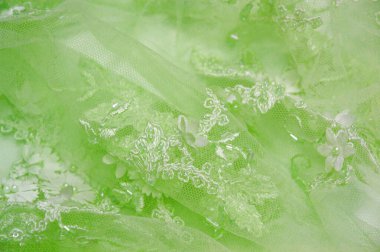 Açık yeşil arkaplan desenli eski dantel ve safir çizgilerin soyut desenli ve kartpostallarda kullanıma uygun desenli dantelli arkaplan.