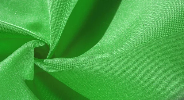 Silk fabric, green forest. Pleats in silky green fabric, close-up, full frame. Texture, background, pattern