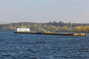 Sonbahar manzarası, nehir, nehirde yapılan çalışmalar, nehir botları, güneşli bir gün, rüzgar dalgaları yükseltiyor, suyun koyu kurşun rengi.,