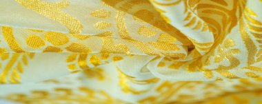 İpek kumaş, zarif renklerde altın pasteller beyaz arka planda, basılmış altın desenli fotoğraf.