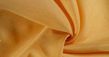 Sarı renkli ipek kumaş. Renkli ipek kumaşın dokusu arka plan olarak kullanılabilir