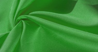 İpek kumaş, yeşil orman. İpeksi yeşil kumaşlı pileler, yakın plan, tam kare. Doku, arkaplan, desen