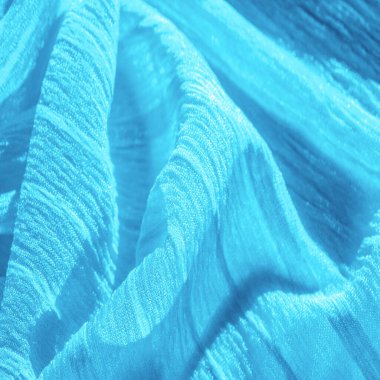 İpek kumaş. Mavi buruşuk kumaş dokusu. Mavi buruşuk, dalgalı yüzey dokusu. Yakın çekim, yumuşak odaklanma. arkaplan, kalıp