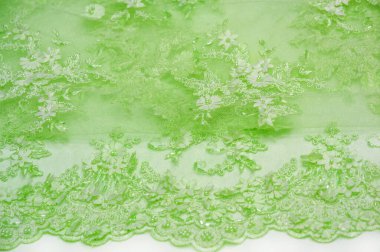 Açık yeşil dantelli, dokulu arka plan. Kartpostallar, posterler, dokular ya da duvar kağıtları için kullanılabilir. Eski dantel ve safir çizgileri olan soyut bir arka planı var..