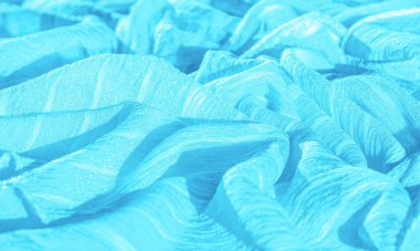 İpek kumaş. Mavi buruşuk kumaş dokusu. Mavi buruşuk, dalgalı yüzey dokusu. Yakın çekim, yumuşak odaklanma. arkaplan, kalıp