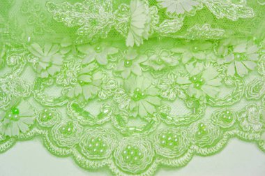 Açık yeşil dantelli, dokulu arka plan. Kartpostallar, posterler, dokular ya da duvar kağıtları için kullanılabilir. Eski dantel ve safir çizgileri olan soyut bir arka planı var..