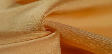 Sarı renkli ipek kumaş. Renkli ipek kumaşın dokusu arka plan olarak kullanılabilir