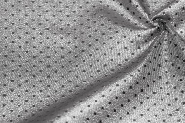 Küçük polka şeklinde metalik bir parıltıya sahip kumaş, siyah, soyut bir polikrom desen, uzay çağı estetiğine sahip siyah bir arkaplan karşısında parıldıyor ve bu kumaşa fütüristik bir gelecek hissi veriyor.