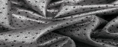 Küçük polka şeklinde metalik bir parıltıya sahip kumaş, siyah, soyut bir polikrom desen, uzay çağı estetiğine sahip siyah bir arkaplan karşısında parıldıyor ve bu kumaşa fütüristik bir gelecek hissi veriyor.