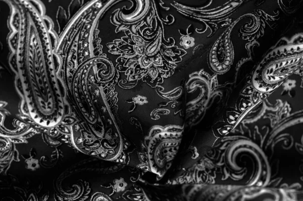 Paisley black-white pattern on a black background. decorated the bandanas of cowboys and bikers popularized by The Beatles, ushered in the era of rock and roll.