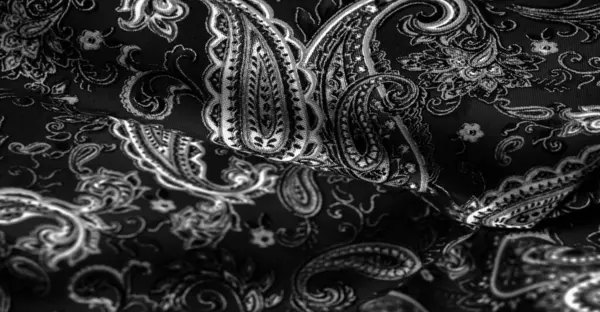 Paisley black-white pattern on a black background. decorated the bandanas of cowboys and bikers popularized by The Beatles, ushered in the era of rock and roll.