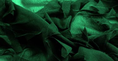 Doku. Geçmişi. Yeşil ipek kumaş, yukarıdan görünüyor. Pürüzsüz yeşil ipek ya da saten lüks kumaş dokusu, kopyalama alanı olan soyut bir arkaplan olarak kullanılabilir.