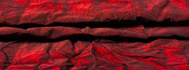 Kırmızı kumaş. Bu önü saten, arkası krep olan orta ağırlıklı bir ipek. Zarif, zengin kumaşlar ve güzel parıltılar lüks tasarımlara izin verir..