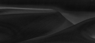 Bulanık siyah ipek kumaş. Gece gökyüzündeki bir yıldız gibi parlak ve parlak, tafta gibi bir vücudu var ama ince bir parıltı yaratan pürüzsüz bir yüzeyi var..