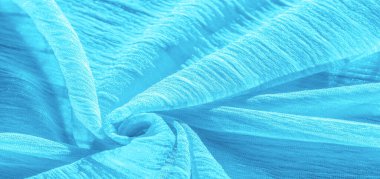 İpek kumaş. Mavi buruşuk kumaş dokusu. Mavi buruşuk, dalgalı yüzey dokusu. Yakın çekim, yumuşak odaklanma. arkaplan, kalıp