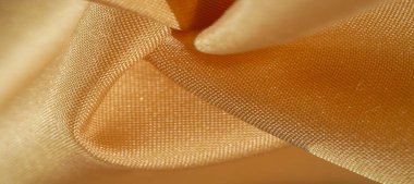 Sarı renkli ipek kumaş. Renkli ipek kumaşın dokusu arka plan olarak kullanılabilir
