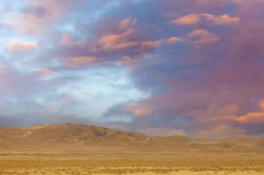 Steppe, prairie, plain, pampa. As the sun gracefully dips below the horizon, a vibrant kaleidoscope of hues illuminates the secluded field, offering a moment of calm and awe. Sunset Serenity Magic clipart