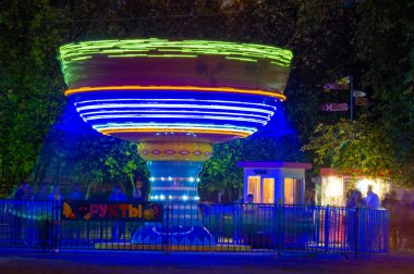 Geceleri eşsiz dalgıç atlıkarıncaları beyaz oval daireler büyüleyici bir performans yaratıyor. Sihirli gece eğlencesi için atmosfer ve atmosfer yaratıyor.