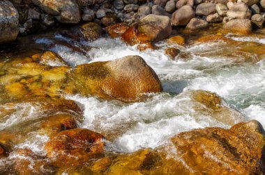Doğadaki akan suyun güzelliğini yakala. Fotoğrafçılık doğal manzaraların uyumu ve sükunetini gösteriyor. Düz taşların karmaşık detaylarını yakalamaya odaklan.