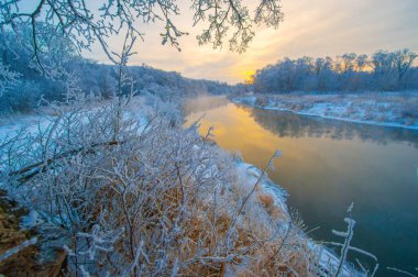 Buz Şafağı 'ndaki kış harikalar diyarının büyüsünü tecrübe et. Altın güneşin altındaki donmuş nehrin güzelliğinin tadını çıkar. Bu büyüleyici sahnede dünyanın tuhaf dönüşümüne tanık olun..