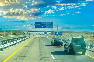 Uzağa uzanan beton bir yolu olan güzel bir çayır manzarası. Gün batımının çarpıcı renkleri gökyüzünü aydınlatıyor. Huzurlu ve huzurlu sahne, 10. 07 numara. 2020 yılı. Kazakistan Almatı
