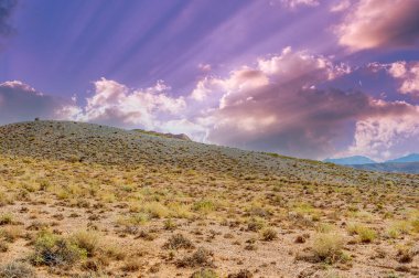 Boguty 'nin Kızıl Dağları. Gün batımında dağların dinginliğini içine çek, sonsuz olasılıklar ve sınırsız güzellikler hakkında hikayeler fısıldayan büyüleyici bir parıltı yayar..