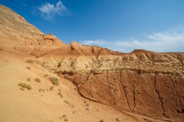 Red Boguty Dağları 'nın nefes kesici güzelliğini tecrübe edin. Ufkun ötesinde büyüleyici bir günbatımına tanık olun. Kendinizi kumla gökyüzünün uyum içinde buluştuğu huzurlu bir ortama daldırın..