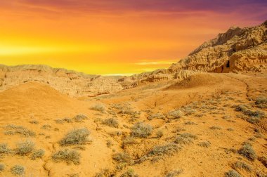 Gün batımında Red Bogut Dağları 'nın çarpıcı güzelliğinin tadını çıkarın. Çöl sıcağı dağılırken kendinizi sükunete daldırın. Dağları renklendiren kırmızının büyüleyici tonlarını yakala..