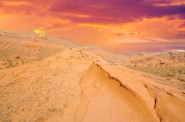 Kızıl Boguta Dağları 'nda gün batımının çarpıcı güzelliğinin tadını çıkar. Güneşin, sivri tepeleri aydınlatan altın parıltısına tanık olun. Nefes kesen manzara ve renklerden mest ol